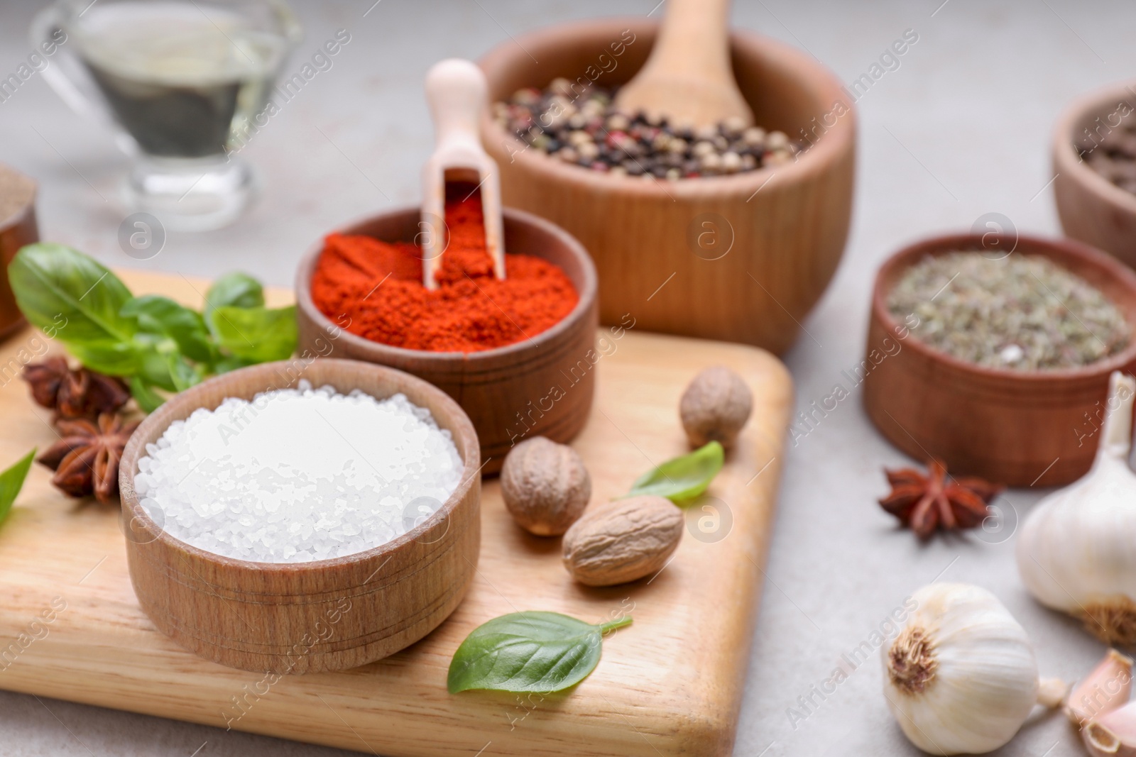 Photo of Mortar with different spices on light grey table, closeup