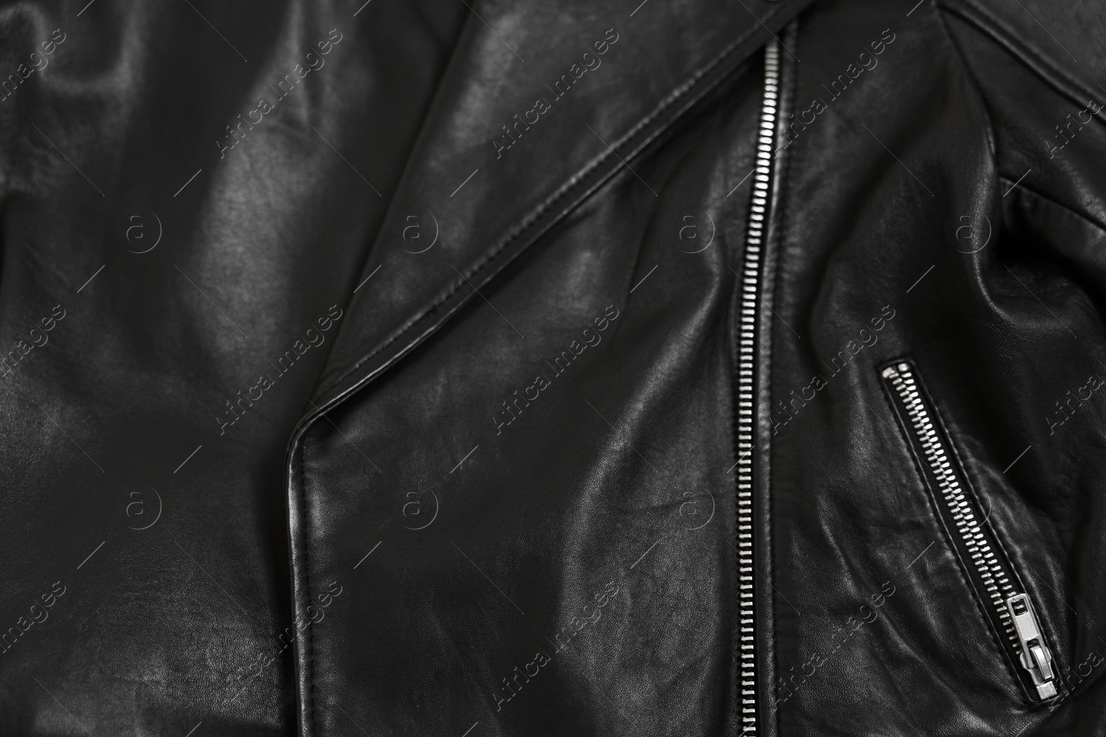 Photo of Texture of black leather jacket with zipper as background, top view