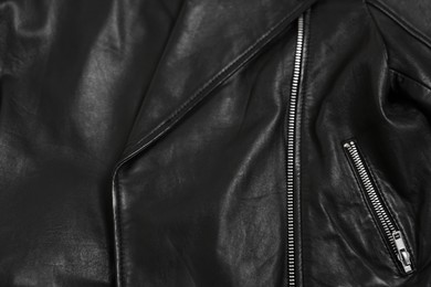 Texture of black leather jacket with zipper as background, top view