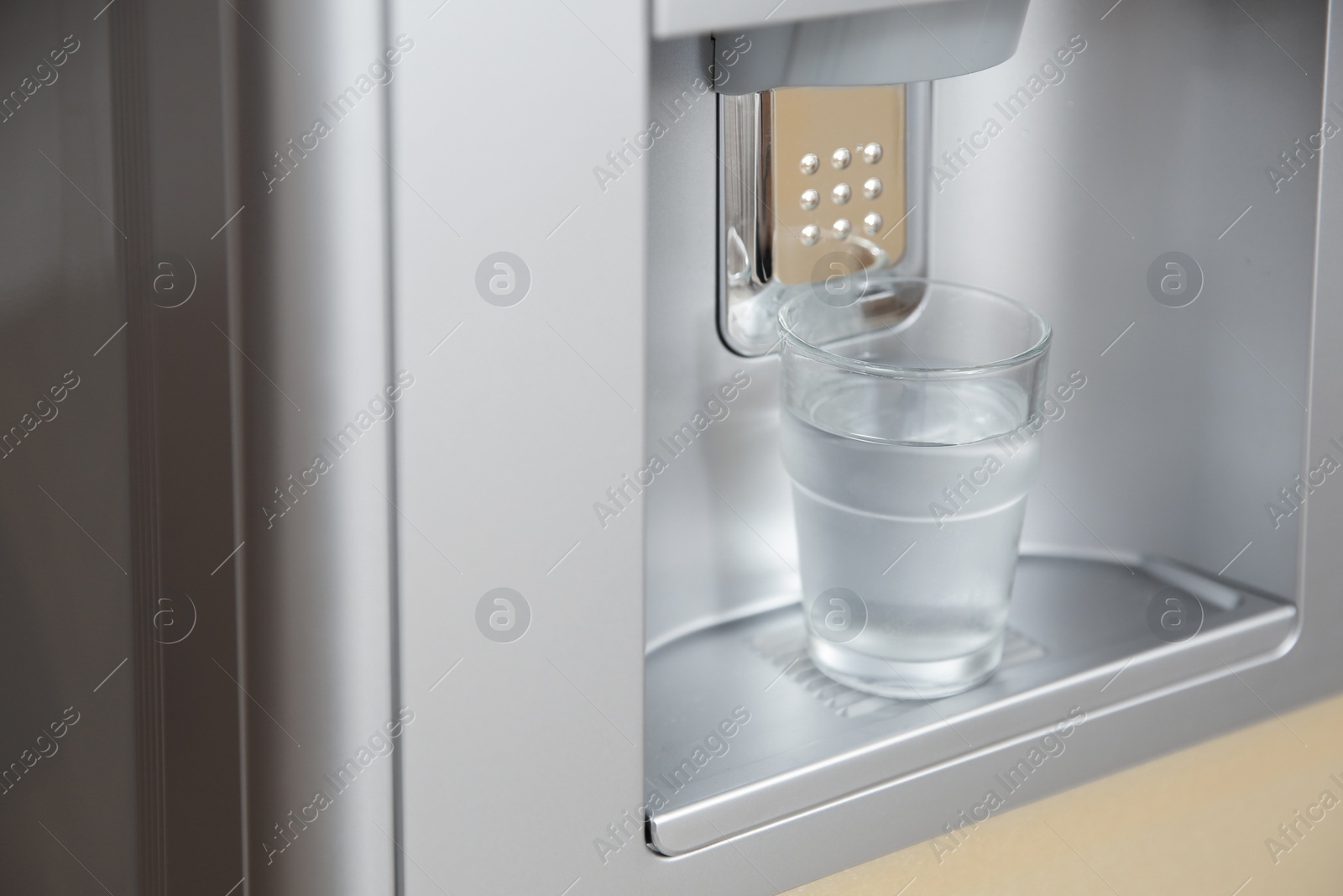 Photo of Modern cooler with glass of water, closeup