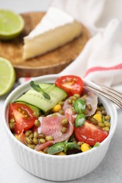 Photo of Bowl of salad with mung beans on white table, closeup