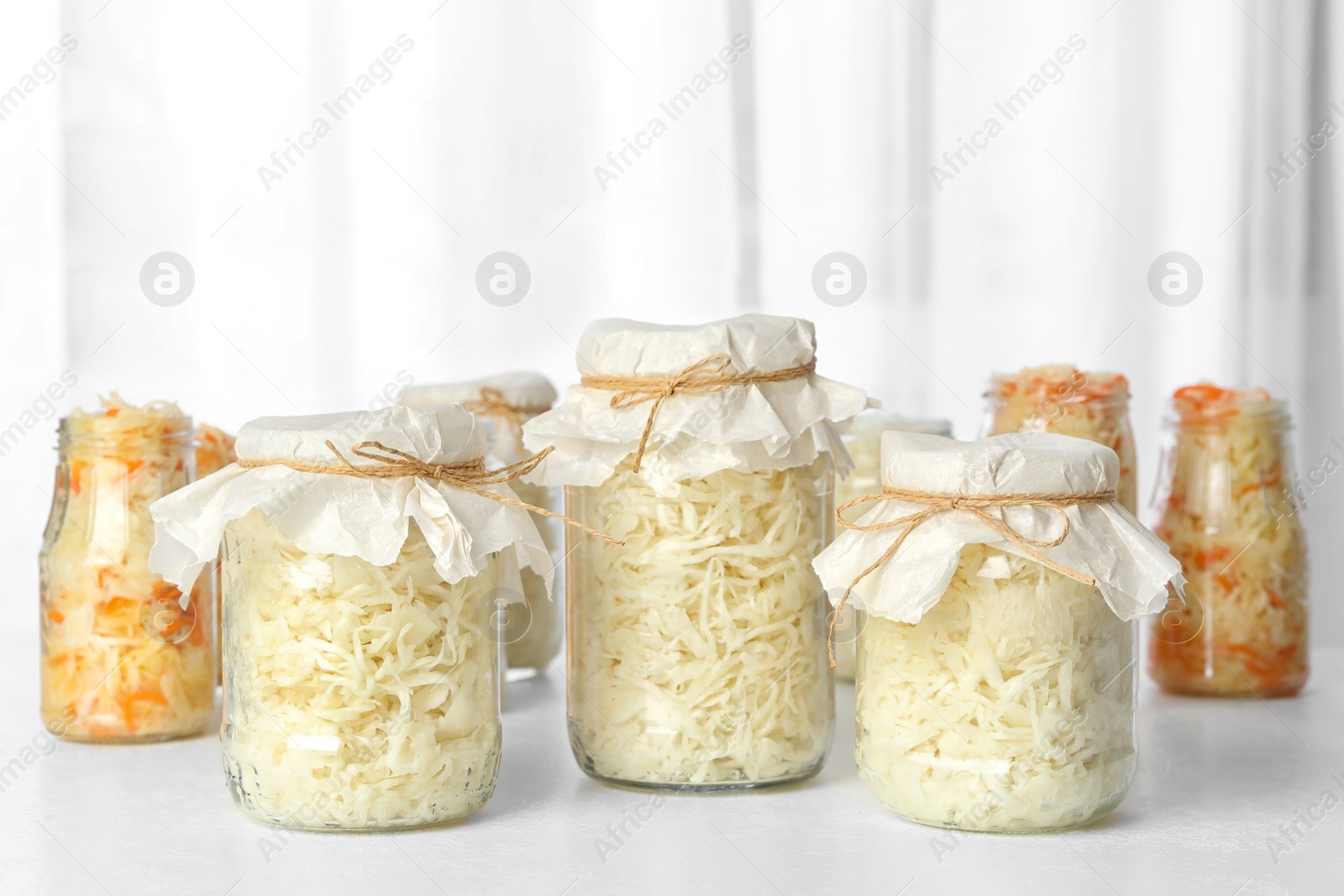 Photo of Tasty homemade fermented cabbage on white table