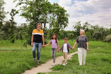 Photo of Cute children with grandparents walking in park
