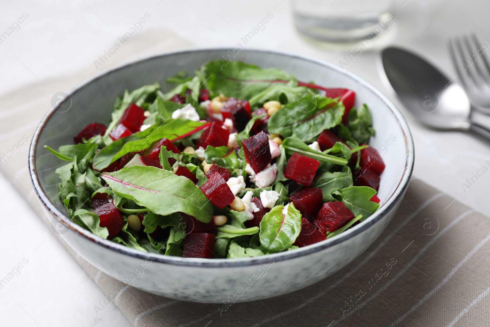 Photo of Delicious beet salad served in bowl on table, closeup