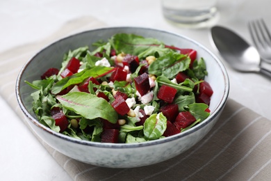 Photo of Delicious beet salad served in bowl on table, closeup