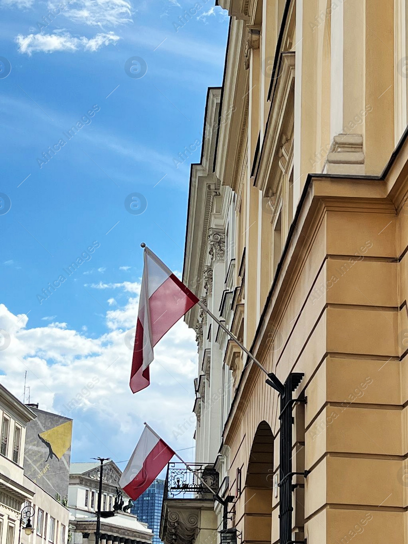 Photo of WARSAW, POLAND - JULY 17, 2022: Building facade with flags on sunny day