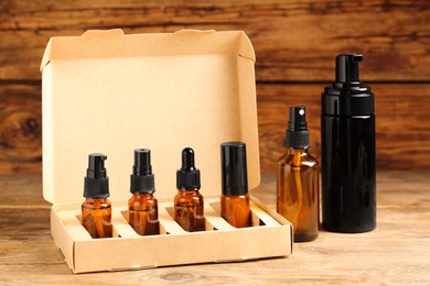 Photo of Bottles with oil on wooden table. Natural cosmetics