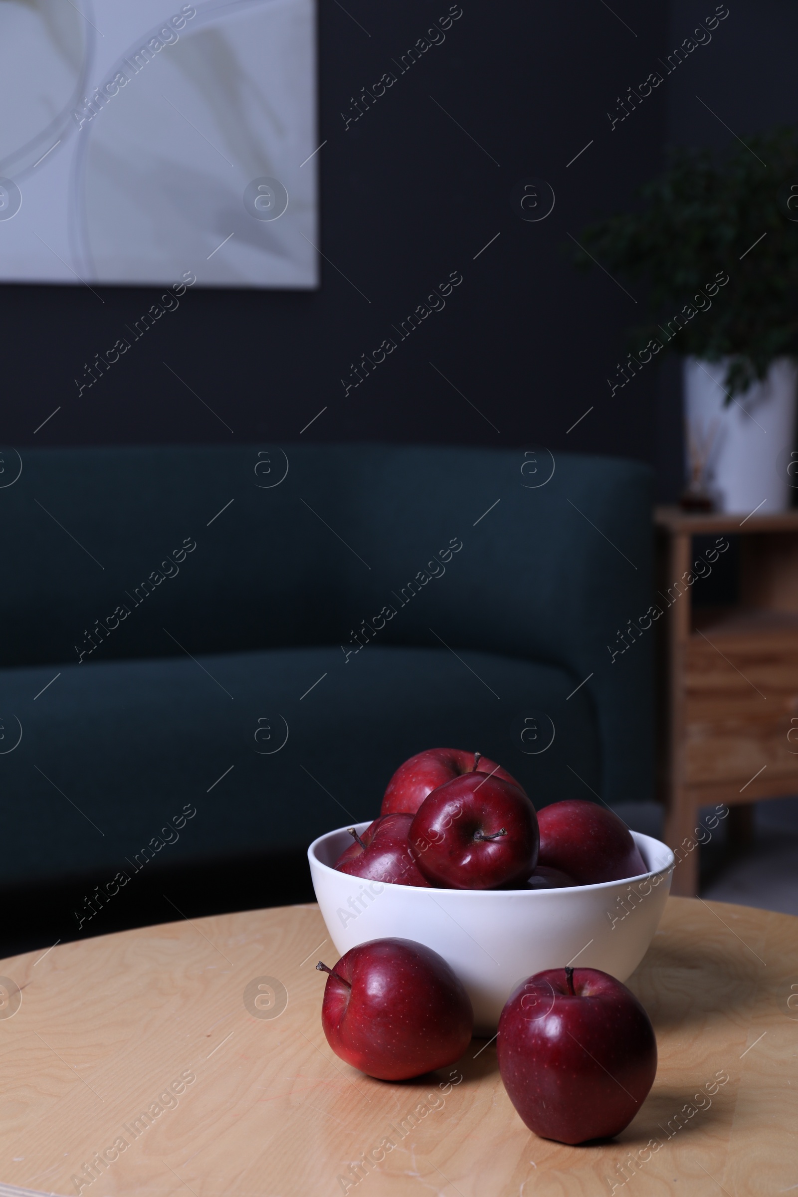 Photo of Red apples on wooden coffee table in room