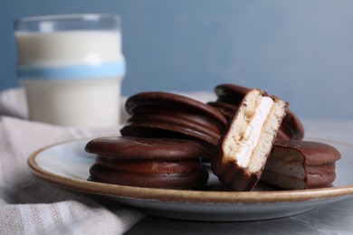 Tasty choco pies and milk on grey table, closeup view