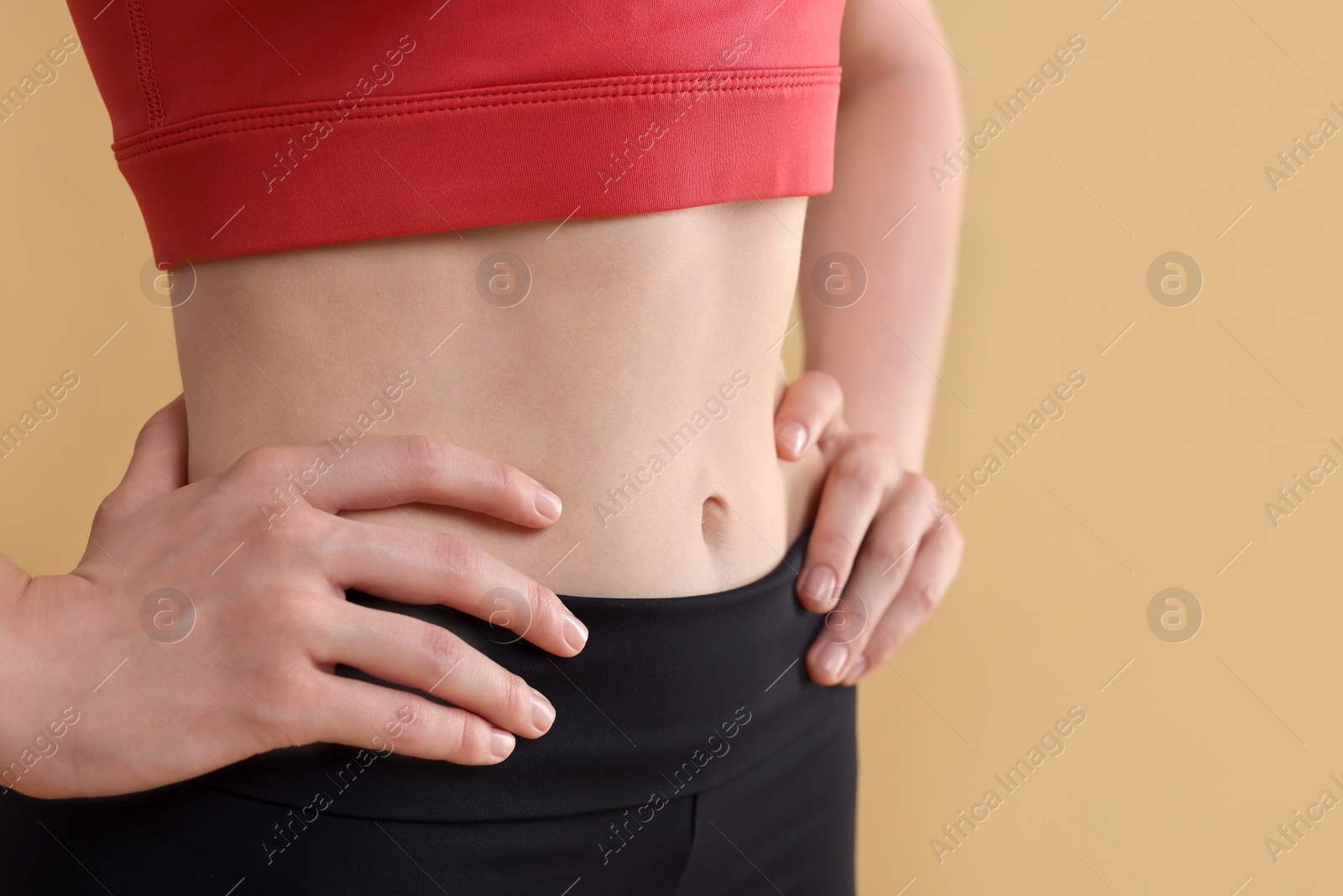 Photo of Young woman in sportswear on beige background, closeup. Space for text