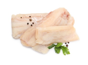 Photo of Pieces of raw cod fish, parsley and peppercorns isolated on white, top view