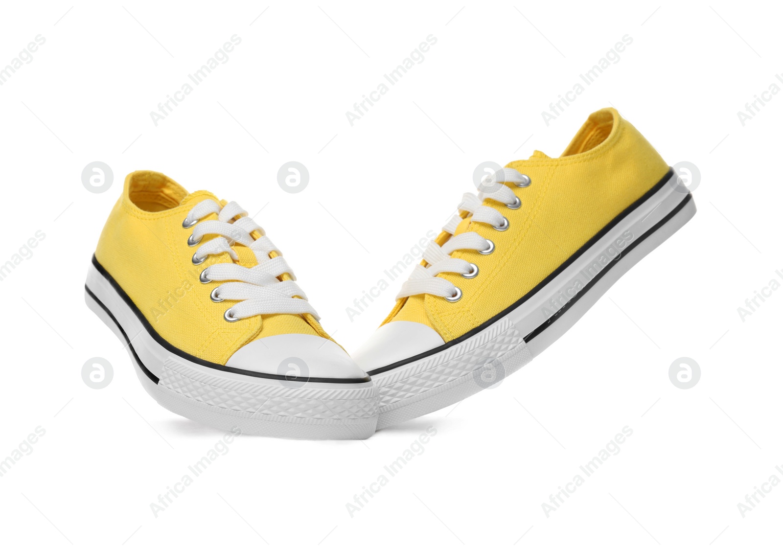 Photo of Pair of yellow classic old school sneakers on white background