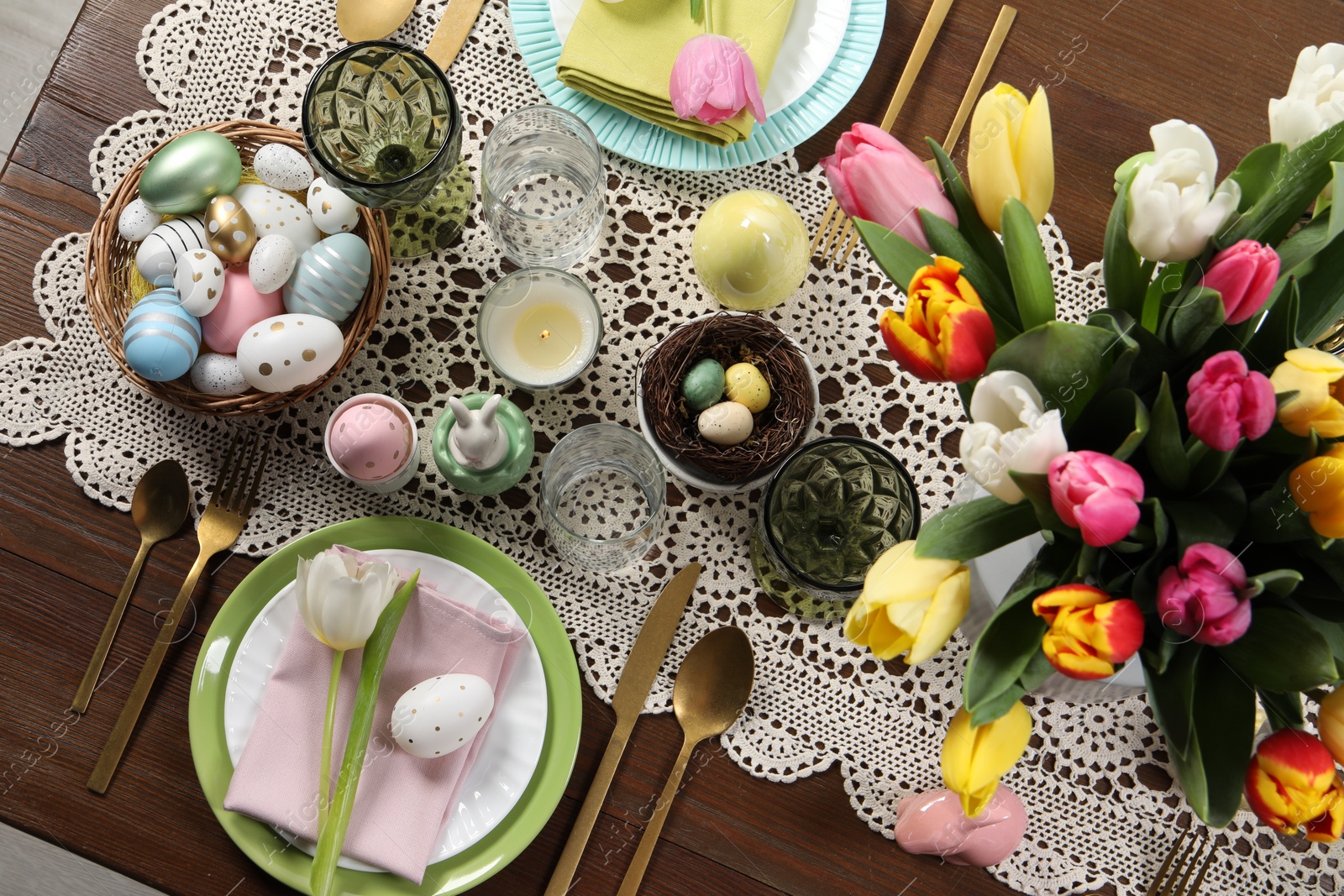 Photo of Festive table setting with beautiful flowers, flat lay. Easter celebration