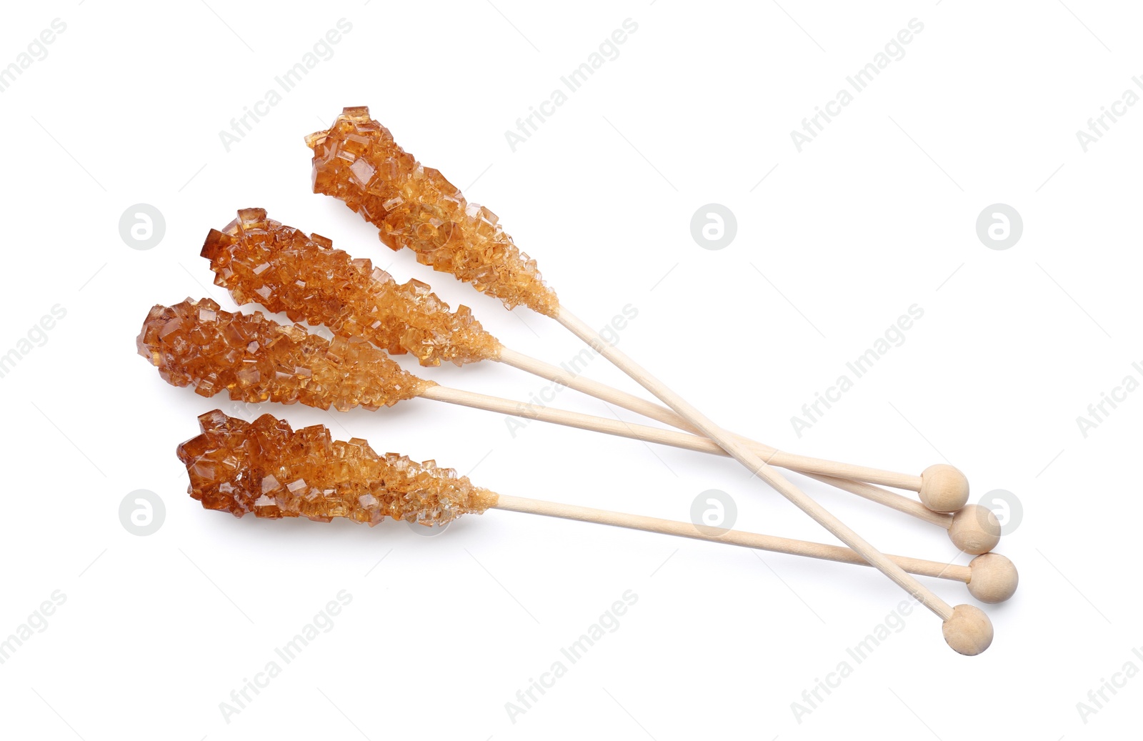 Photo of Wooden sticks with sugar crystals isolated on white, top view. Tasty rock candies