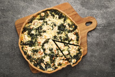 Delicious homemade spinach quiche on gray table, top view