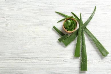 Photo of Flat lay composition with aloe vera leaves on wooden background. Space for text