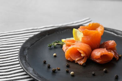 Photo of Plate with fresh sliced salmon fillet and lemon on table