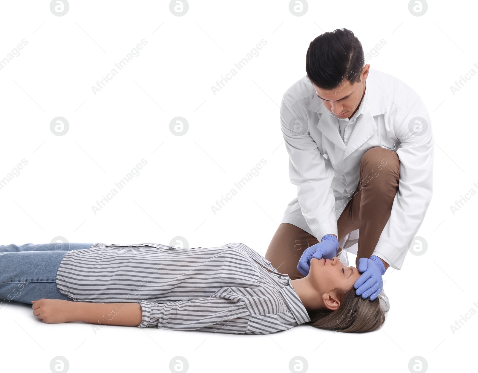 Photo of Doctor in uniform practicing first aid on woman against white background