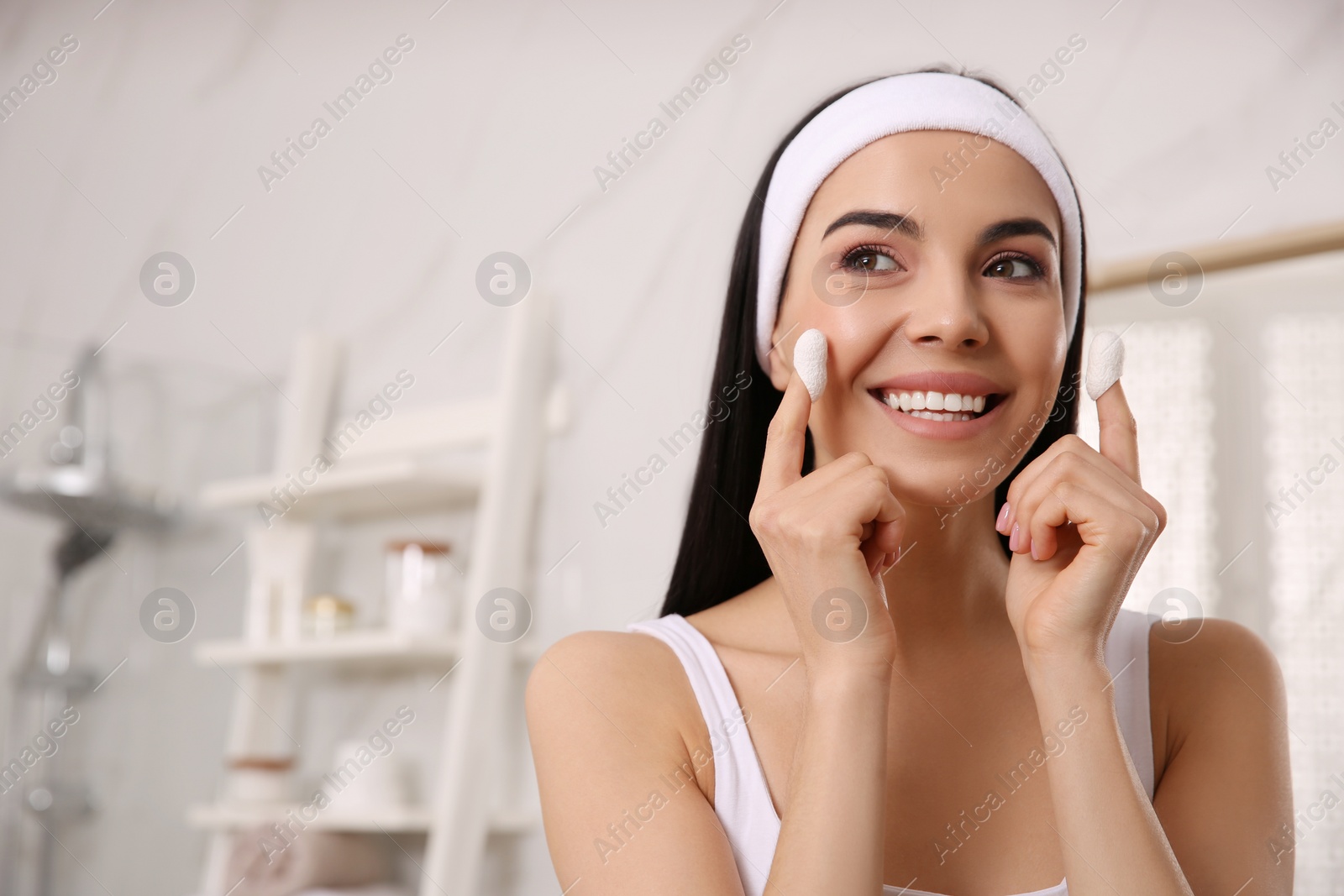 Photo of Woman using silkworm cocoons in skin care routine at home