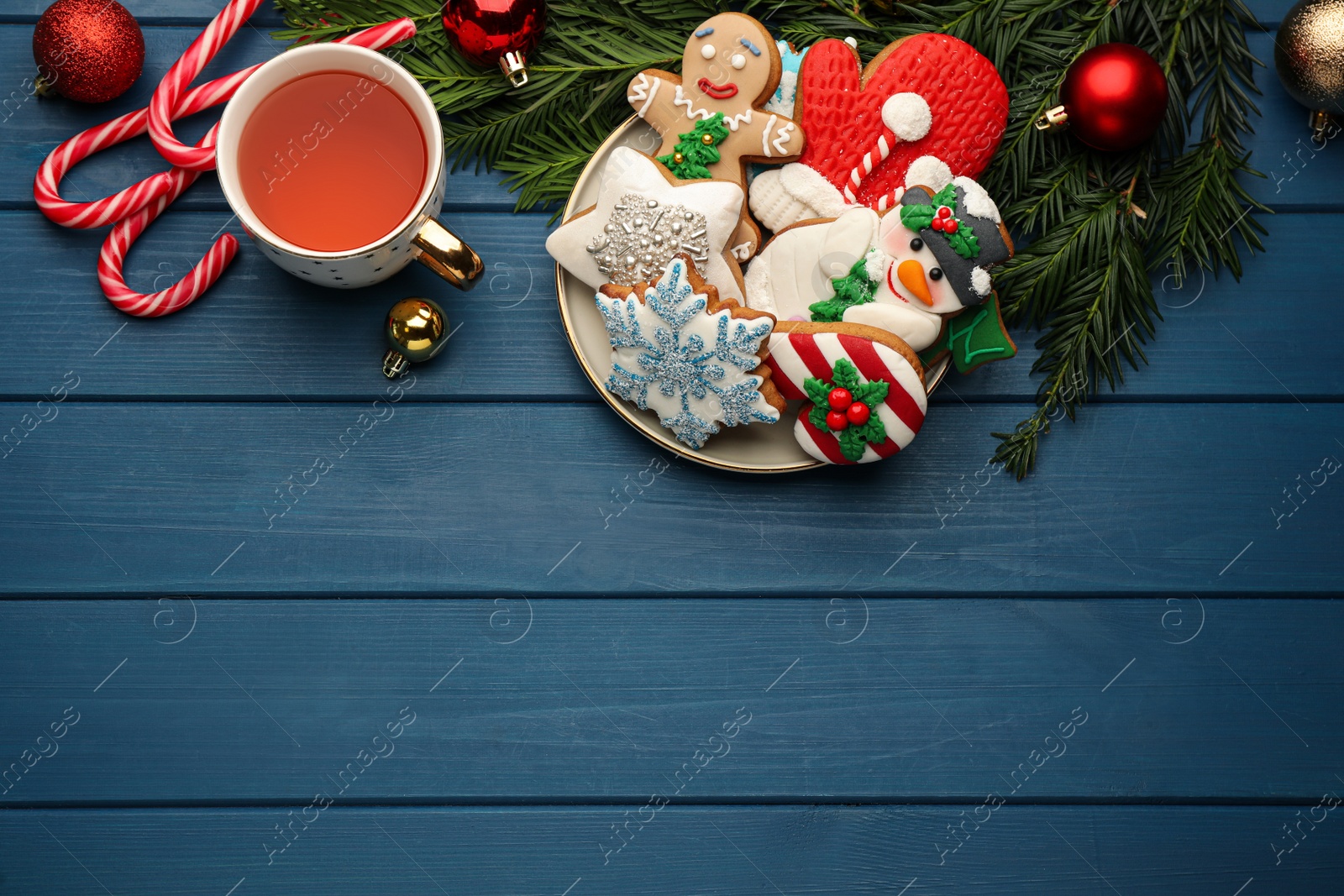 Photo of Delicious homemade Christmas cookies, drink and festive decor on blue wooden table, flat lay. Space for text