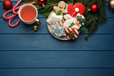 Delicious homemade Christmas cookies, drink and festive decor on blue wooden table, flat lay. Space for text