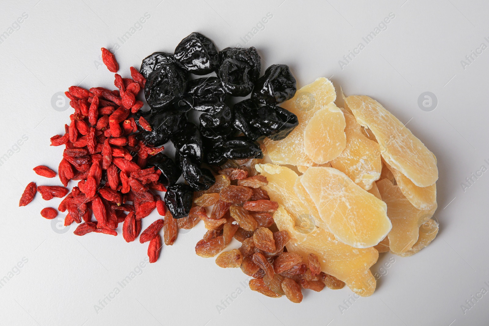 Photo of Pile of different dried fruits on white background, top view