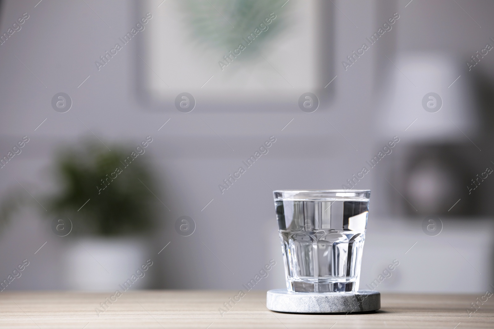 Photo of Glass of clean water on wooden table indoors, space for text