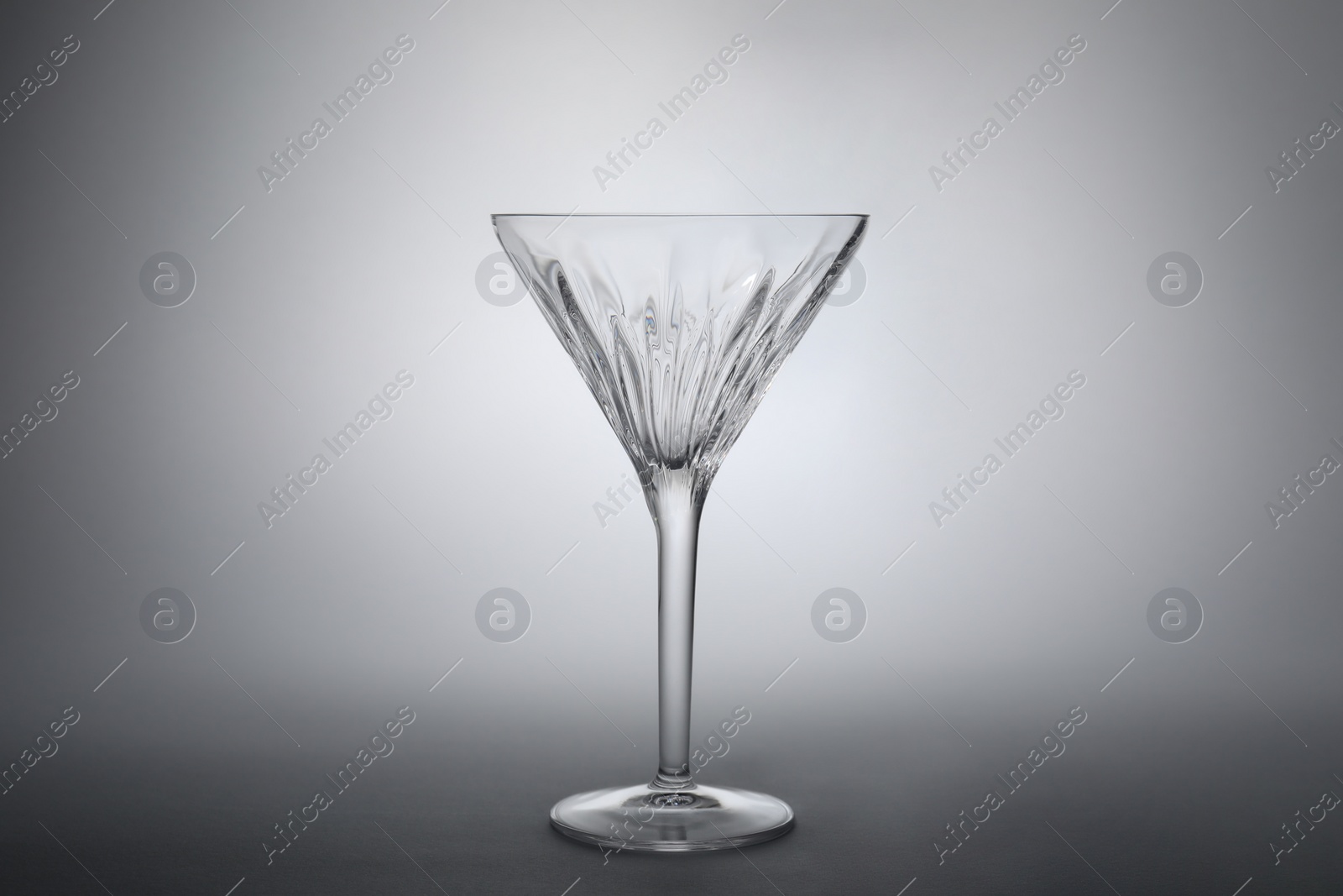 Photo of Elegant empty martini glass on grey background