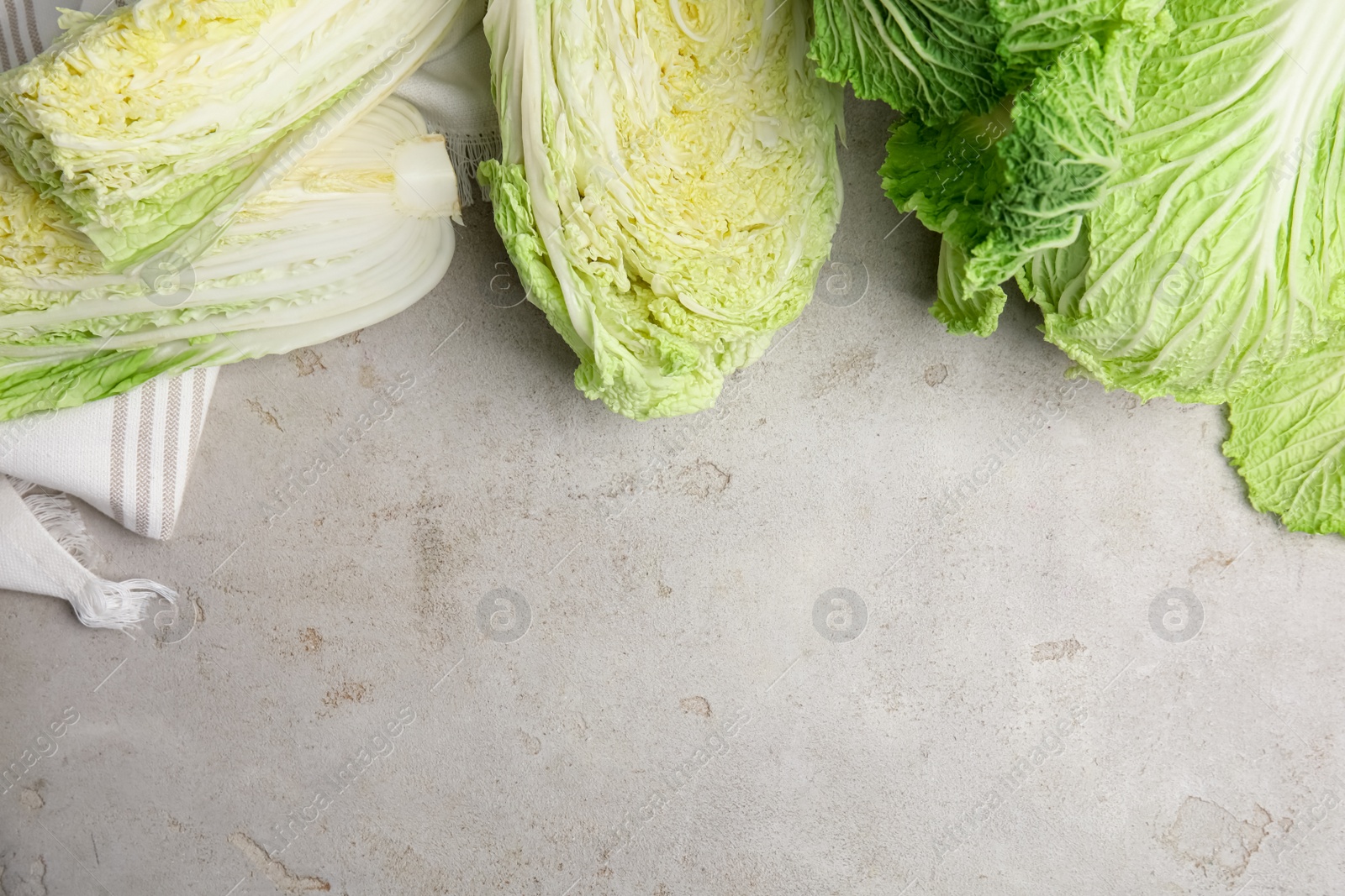 Photo of Cut fresh Chinese cabbages on light grey table, flat lay. Space for text