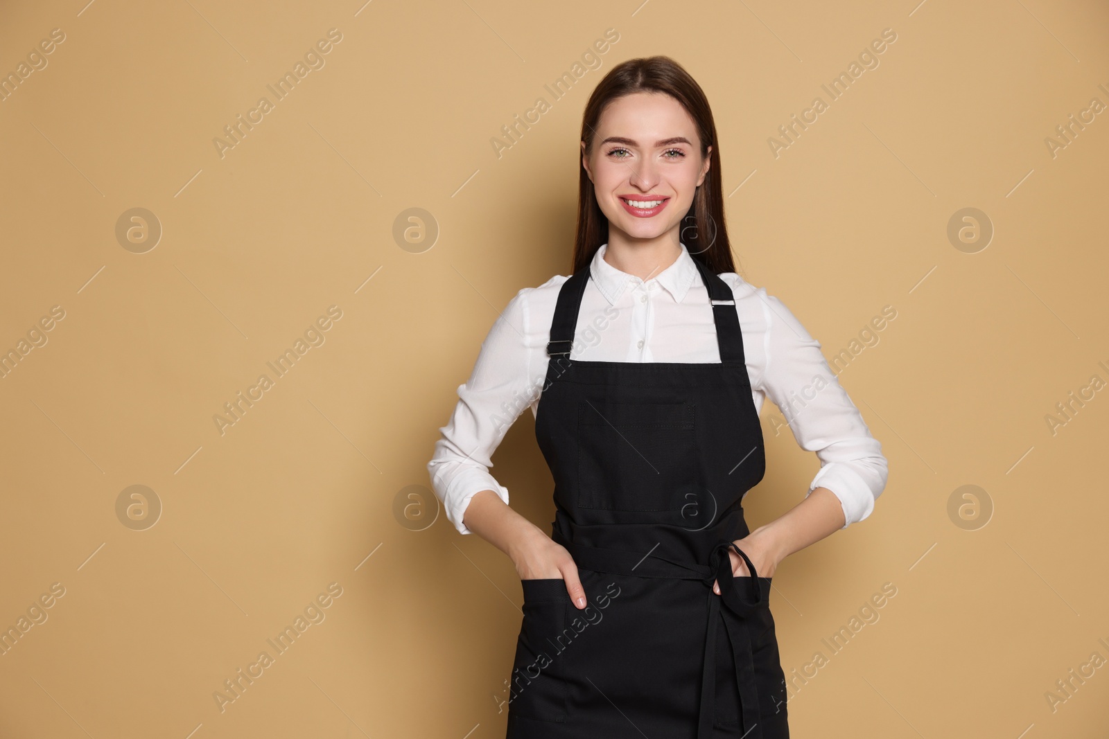 Photo of Portrait of happy hairdresser on beige background. Space for text