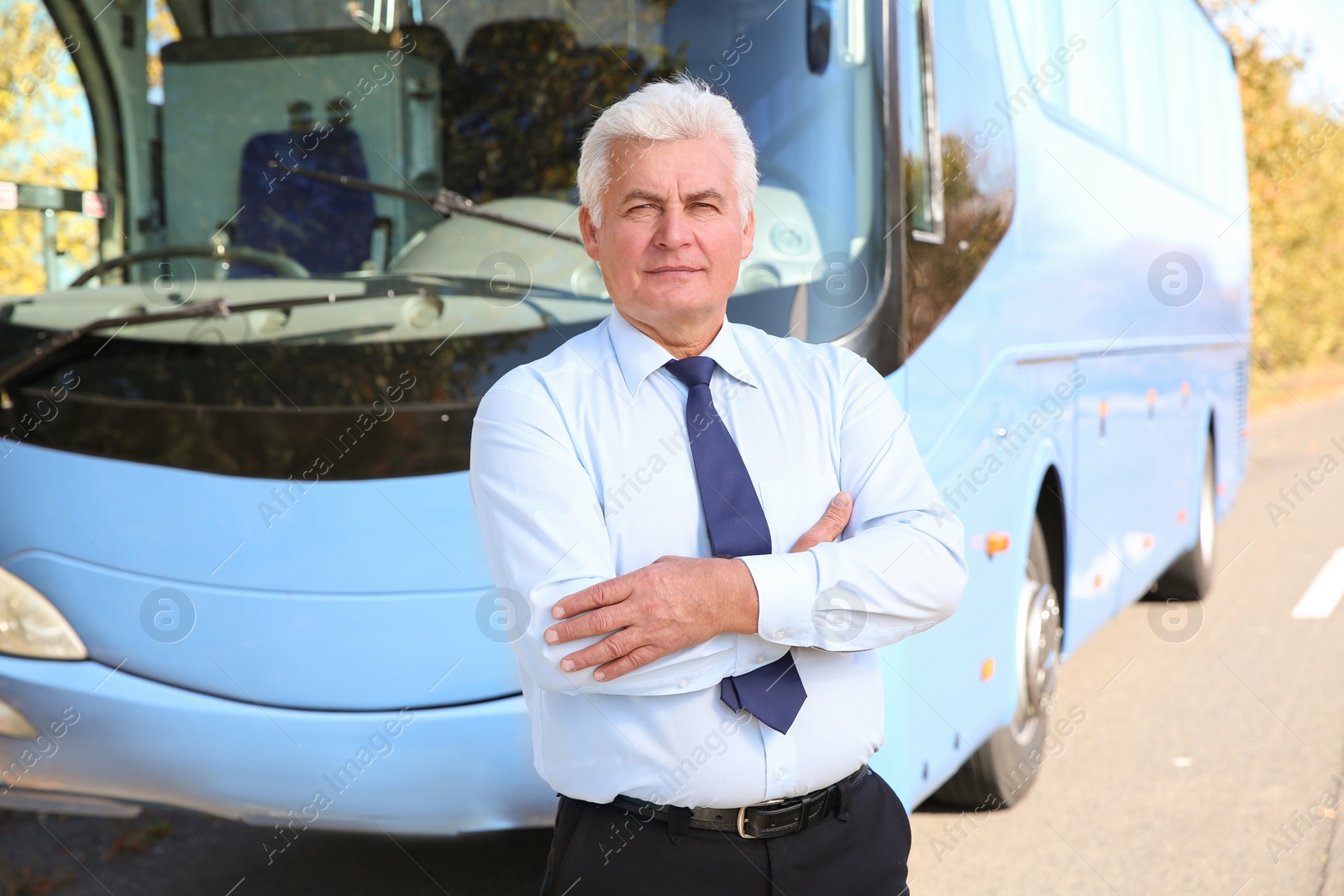 Photo of Professional driver standing near bus. Passenger transportation