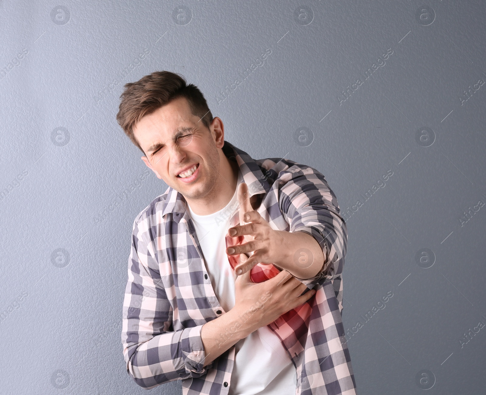 Photo of Young man having heart attack on color background