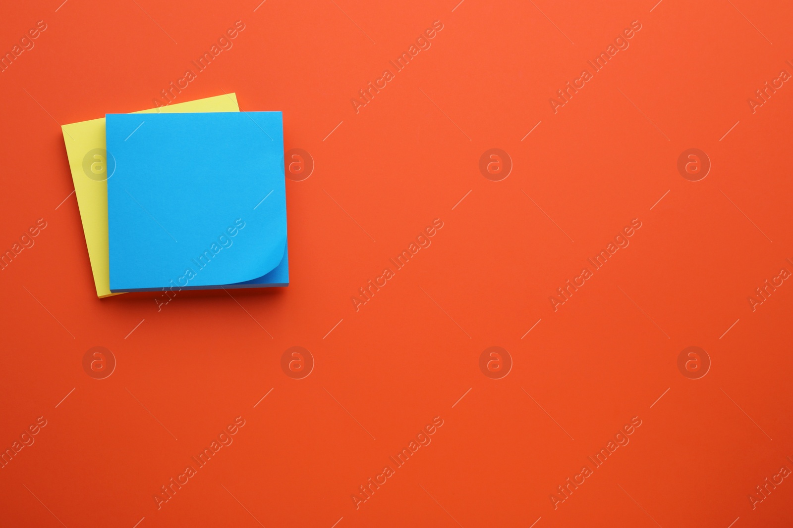 Photo of Paper notes on orange background, top view. Space for text