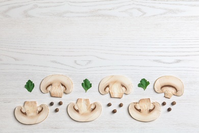 Sliced champignon mushrooms on wooden background, flat lay with space for text