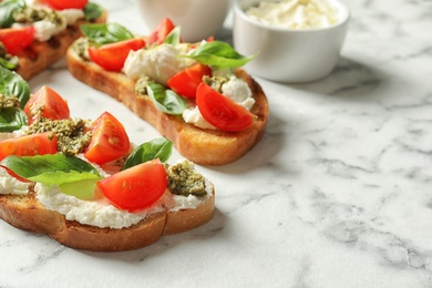 Photo of Toasted bread with tasty cream cheese and tomatoes on marble table. Space for text