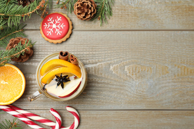 Photo of Aromatic mulled wine on wooden table, flat lay. Space for text