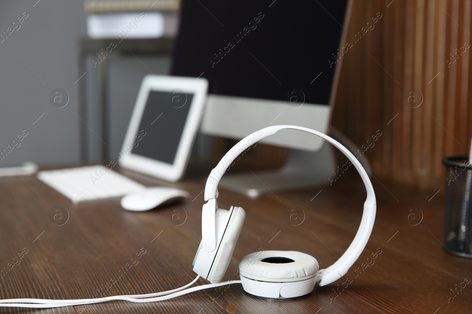 Photo of Stylish headphones on office table. Space for text