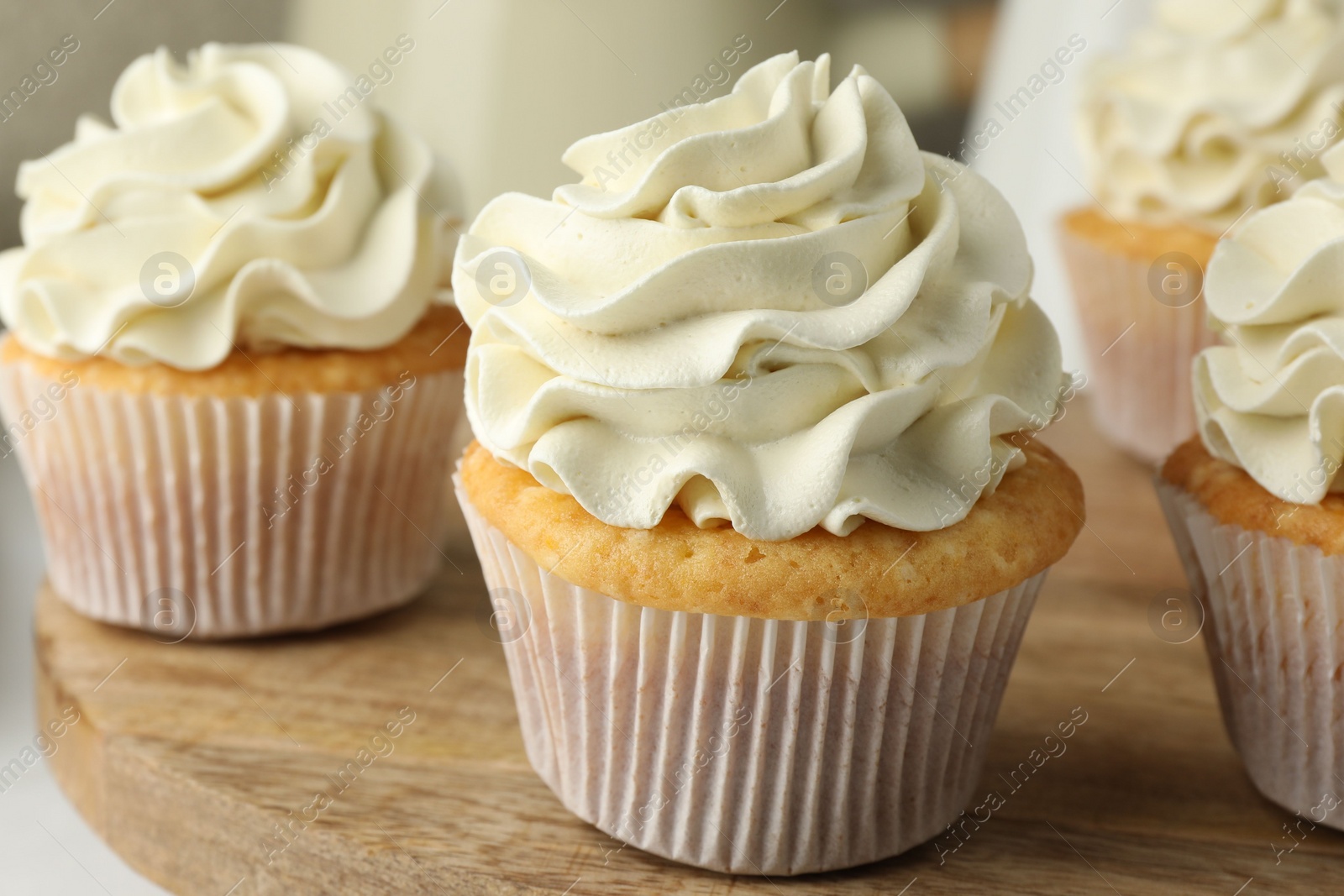 Photo of Tasty vanilla cupcakes with cream on table, closeup