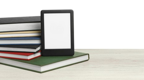 Stack of hardcover books and modern e-book on wooden table against white background. Space for text