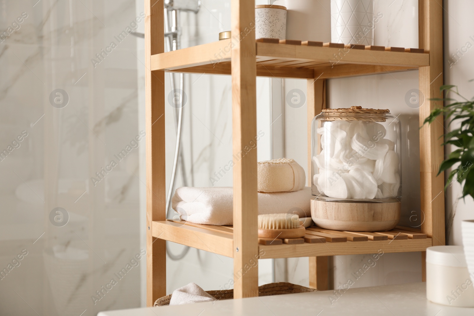 Photo of Shelving unit with toiletries in bathroom interior