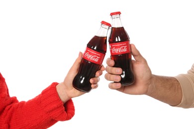 MYKOLAIV, UKRAINE - JANUARY 27, 2021: Couple holding bottles of Coca-Cola on white background, closeup
