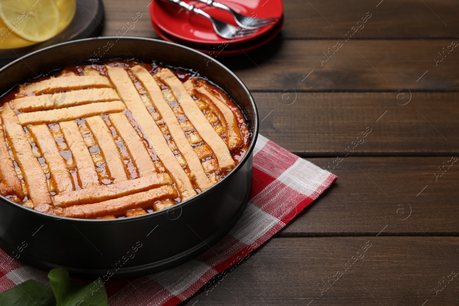 Photo of Delicious apricot pie in baking dish on wooden table, space for text
