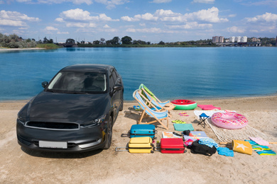 Image of Car and beach accessories on sand near river. Summer trip
