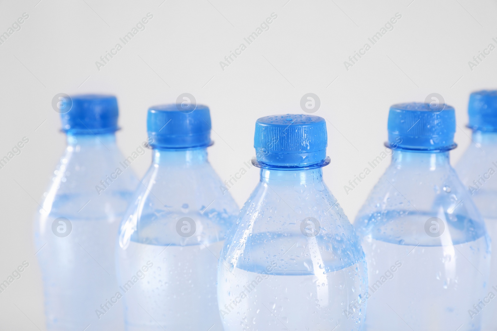 Photo of Plastic bottles with pure water on white background, closeup