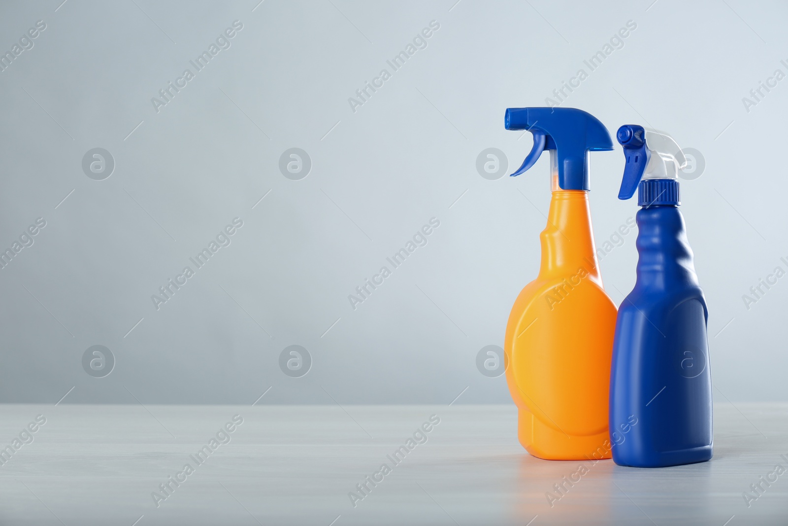 Photo of Bottles of cleaning products on light table. Space for text