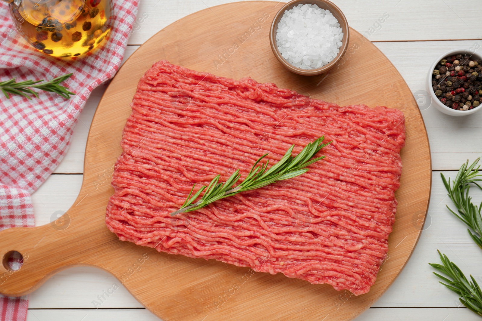 Photo of Raw fresh minced meat with rosemary and spices on white wooden table, flat lay