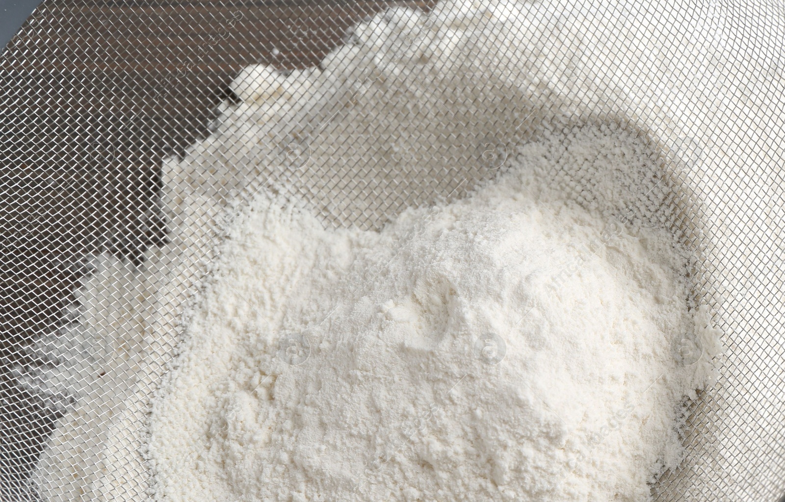 Photo of Sieve and pile of flour on table, above view
