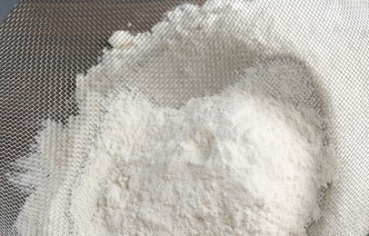 Sieve and pile of flour on table, above view