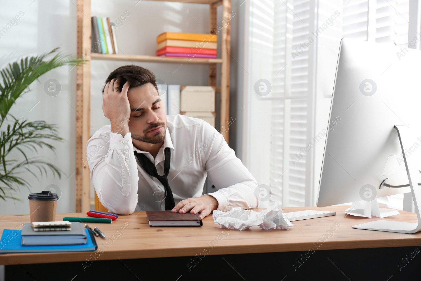 Photo of Lazy employee sleeping at table in office