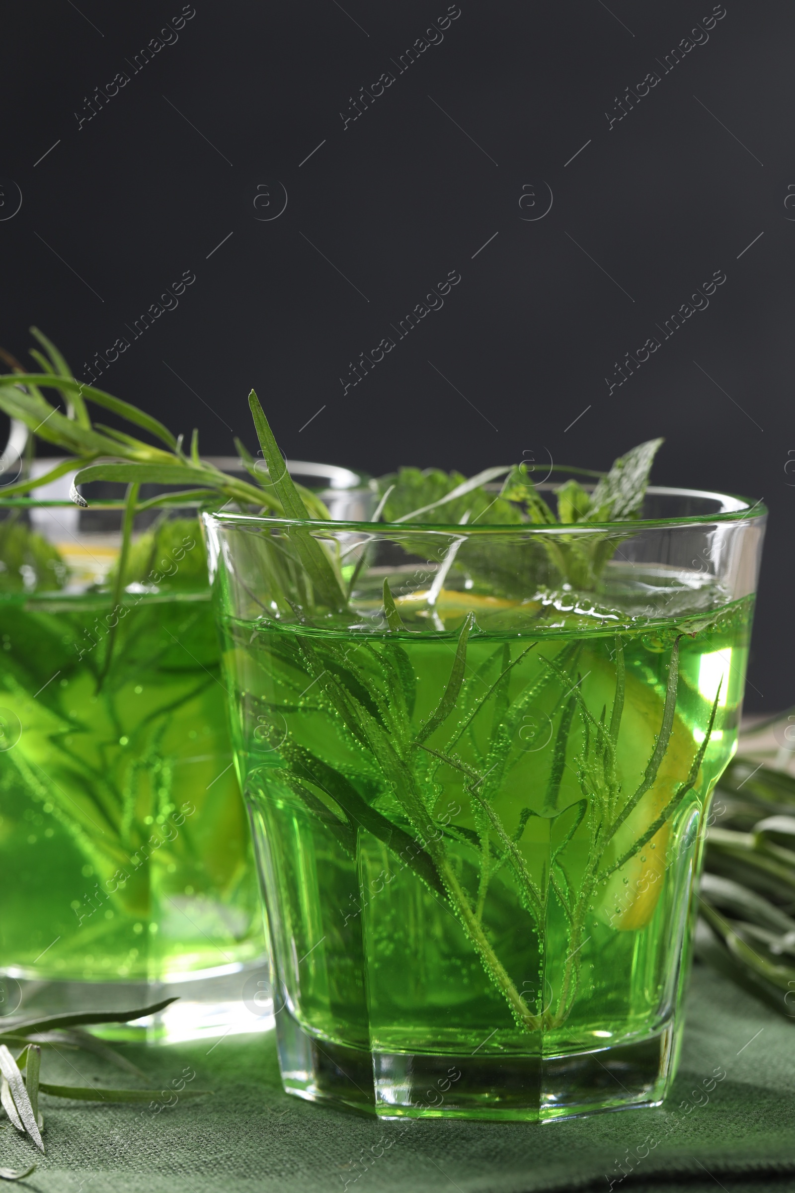 Photo of Glasses of refreshing tarragon drink on table, closeup